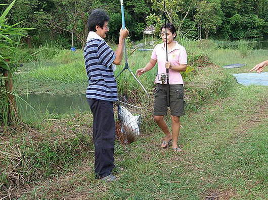 คุณผู้ชายนะครับคือหัวหน้าทีมเทพเนจร(เฮียหร่อย)กำลังช่วยหิ้วปลาขึ้นจากบ่อ ส่วนคุณผู้หญิงที่ตกปลาได้นั