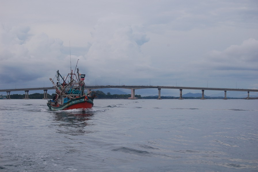 ด้าน หลังเป็นสะพานข้ามแม่น้ำจันทบุรี  (สะพานแหลมสิงค์)